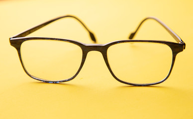 graduated glasses on yellow background