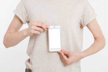 Girl holding white phone. Cellular isolated on white clipping path inside. Top view.Mock up.Copy...