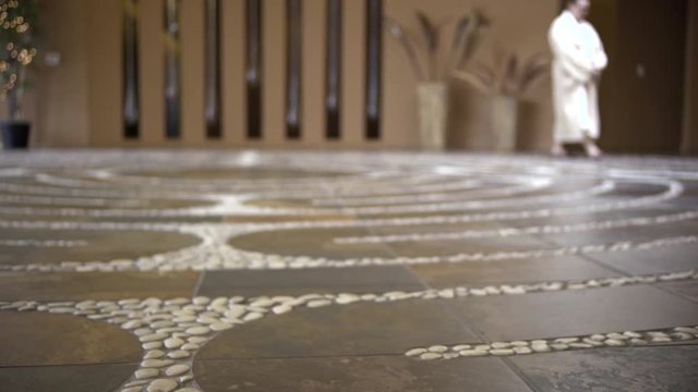 people walking a indoor stone labyrinth 