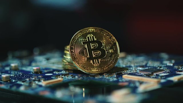 Modern bitcoin mining business. Stack of gold bitcoins on circuit board. Global blockchain technology. Cryptocurrency gpu farms equipment. Bitcoin mining concept