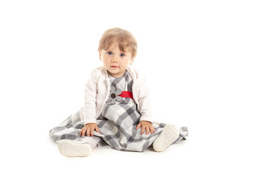 Elegant Happy baby girl 1 year old sitting on the studio floor. White Background. Concept Happiness.