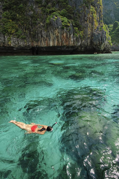 A asian female tourist in a red swimsuit is enjoying Maya Bay.