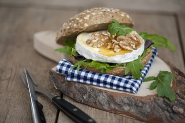  slice of brie - farmhouse creamy-soft cheese made of cow's milk, authentic french cheese on black slate plate with honey, walnuts