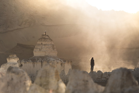 Man Stands In A Misty Mountain Valley Near A Religious  Tibetan Stupa