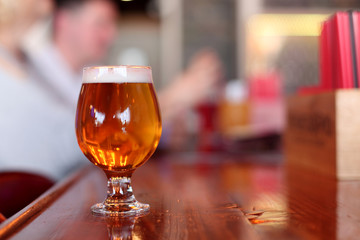 Delicious local brew served in a goblet at bar.