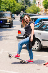 Fototapeta na wymiar Portrait of beautiful teenage girl with skateboard