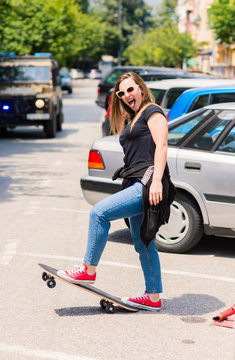 Portrait of beautiful teenage girl with skateboard