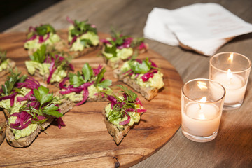 A plate of organic appetizers - avocado and chard toast on gluten free bread.