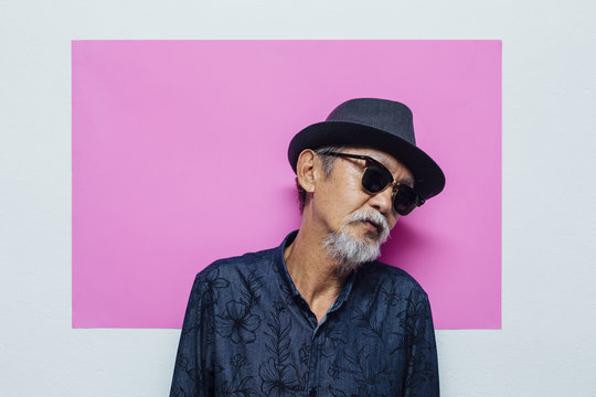 Senior asian man portrait on pink background