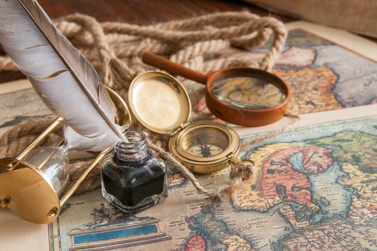 Quill pen and old papers on an old map with vintage items