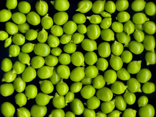 Texture and background of green peas on a black background