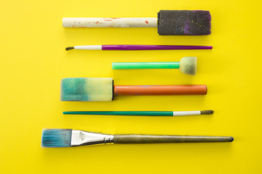 Children's Paint Brushes on a Yellow Background