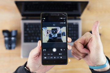 Smartphone in Hand, Thumbs-Up Sign, and Laptop Droste Effect