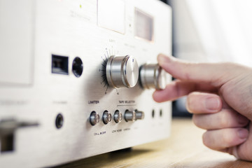 Hand Turning a Dial on a Vintage Hi-Fi Home Stereo - obrazy, fototapety, plakaty