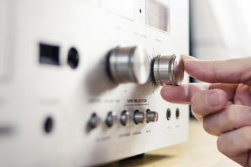 Hand Turning a Knob on a Vintage Home Stereo Equipment - obrazy, fototapety, plakaty