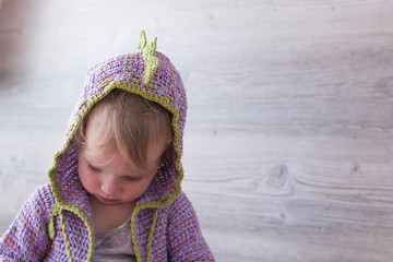 Little Girl in Purple Knitted Hoodie Looking Down with Copy Space © photographyfirm