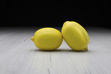 Two Lemons on a Wooden Surface with Dark Background