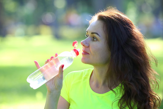 cute young sporty girl drinking water from a bottle