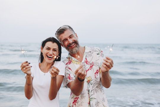 Couple celebrating with sparklers at the beach