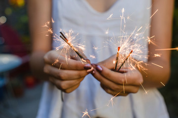 Young girl holding multiple sparklers