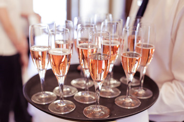 Waiter serving guests with roze wine