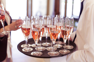 Waiter serving guests with roze wine