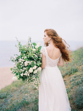 Girl in dress with flowers on beach