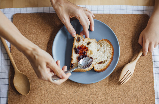 Mother spreading jam on bread