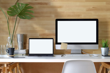 Mockup blank screen desktop and laptop computer on desk.