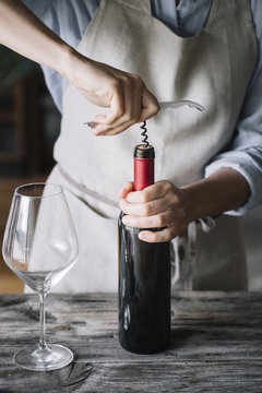 Anonymous woman using corkscrew