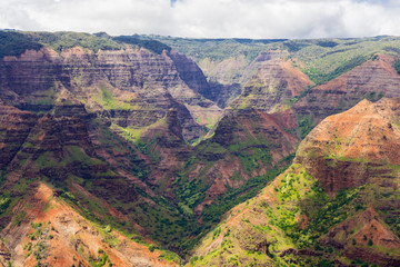 Fototapeta na wymiar Aerial view on a sunny day over Waimea Canyon in Kauai, Hawaii - also known as The Grand Canyon of the Pacific