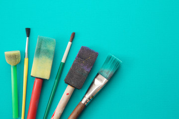 Children's Paint Brushes on a Teal Background