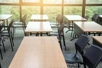Table in a seminar room arranged in lined with chairs.