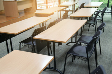 Table in a seminar room arranged in lined with chairs.
