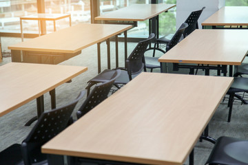 Table in a seminar room arranged in lined with chairs.