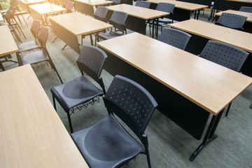Table in a seminar room arranged in lined with chairs.