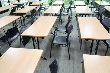Table in a seminar room arranged in lined with chairs.