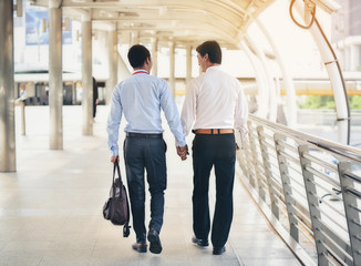 Two Asian business men are walking hand in hand and taking care of each other.The concept of sex couples is correct according to the rights of each person.