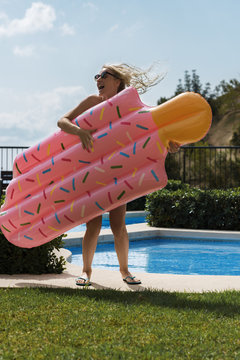 Woman with airbed on poolside