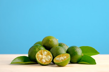 Calamansi on wooden table and blue background