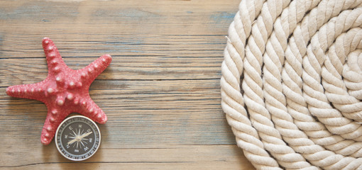 Old rope a shell on a wooden scratched background