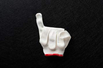 white glove with little finger up on black background