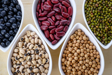 Assortment beans in white ceramic bowl, focus on the Mung Beans. Black, soybean, red kidney , black eye peas and mung beans.