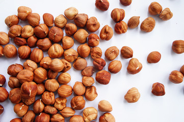 scattered hazelnuts on a white background
