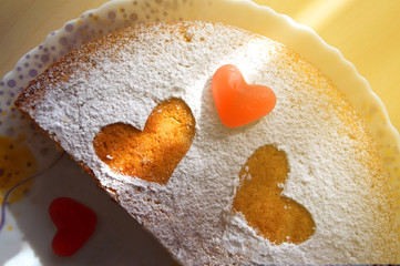 a festive cake sprinkled with powder and hearts of marmalade