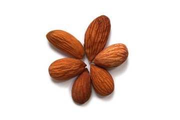 Peeled almonds in the shape of a flower on a white background