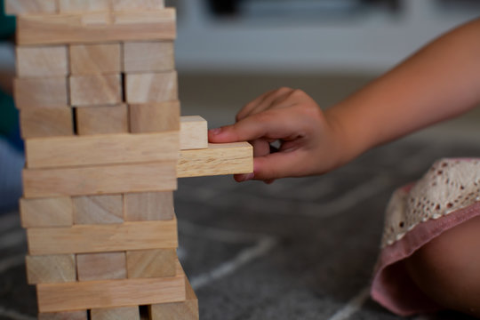 Children building wood blocks at playground. Girl kid playing stacking wood blocks for meditation practice.Hand movement control Building Computational Skills