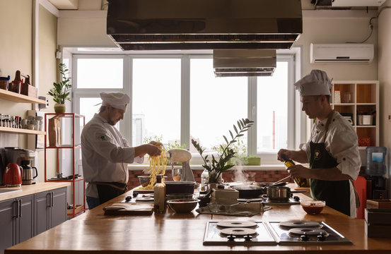 Two cooks on kitchen of restaurant