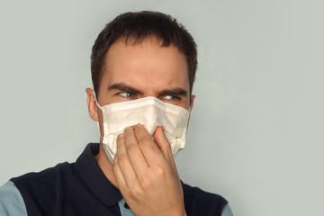 young father holding dirty dirty diaper in one hand fingers with gas mask over white background....