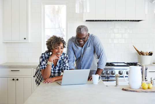 Senior African American on computer in the kitchen together